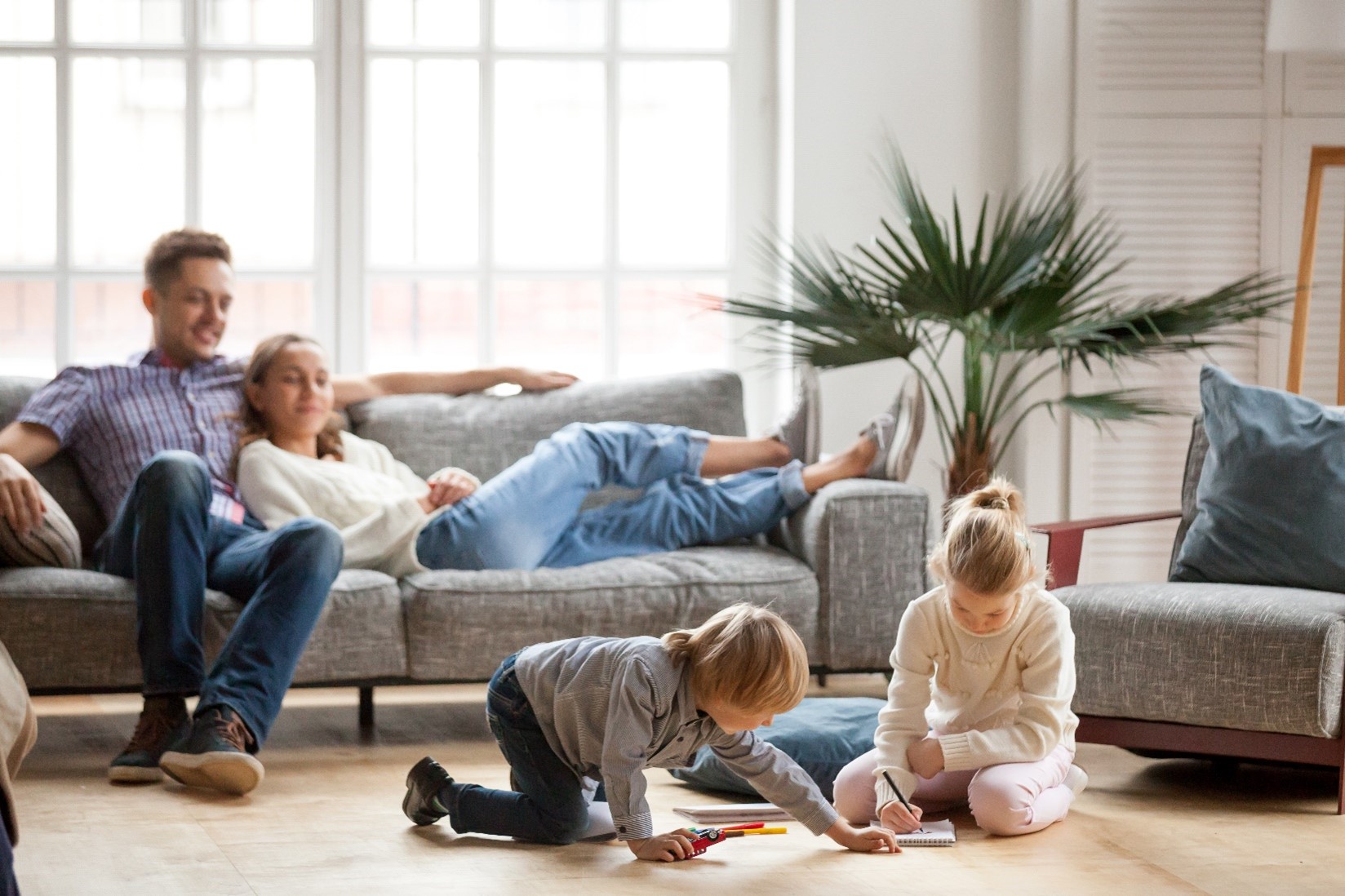 A family sitting in the living room together. 