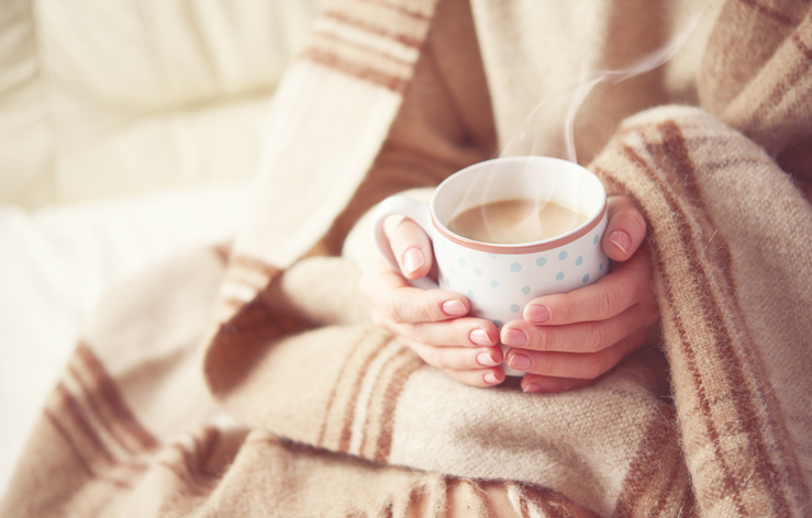 warm cup of hot coffee warming in the hands of a girl