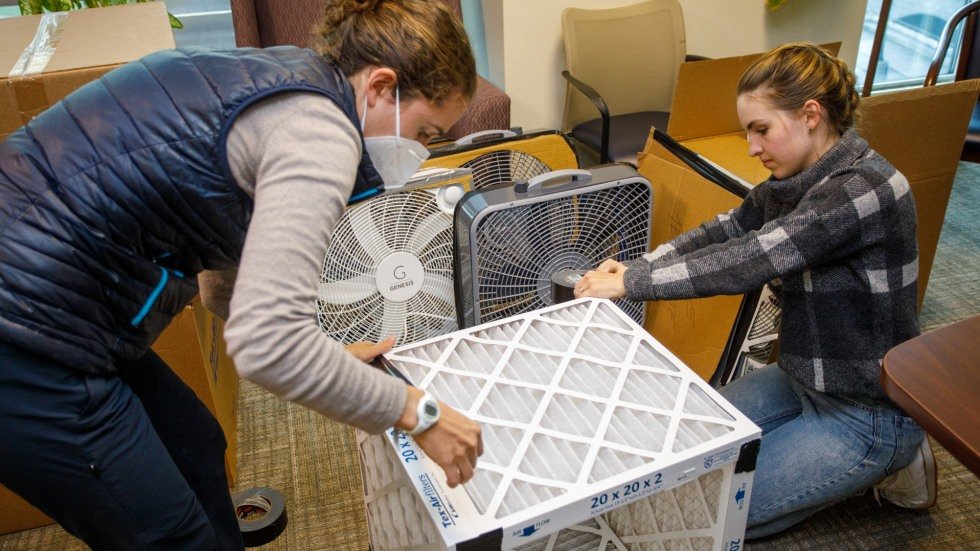 kids putting box fan project together in classroom with teachers