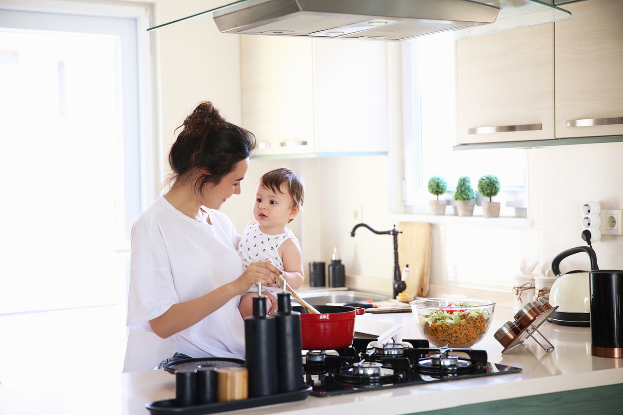 Mother of a woman with a baby cooks the food