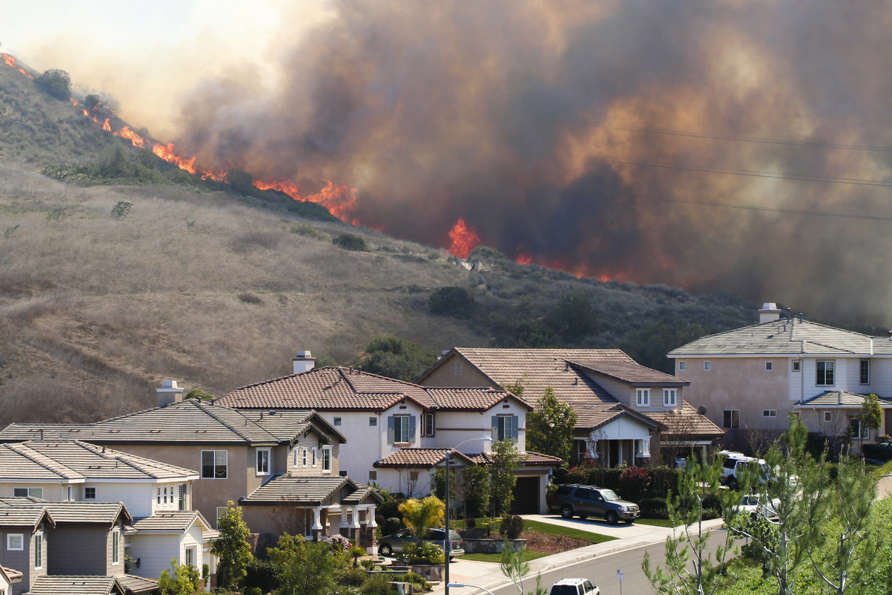 A recent southern california brush fire burning extremely close to homes.